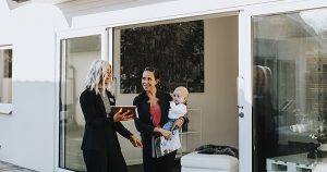 The agent showing a woman with a baby a home